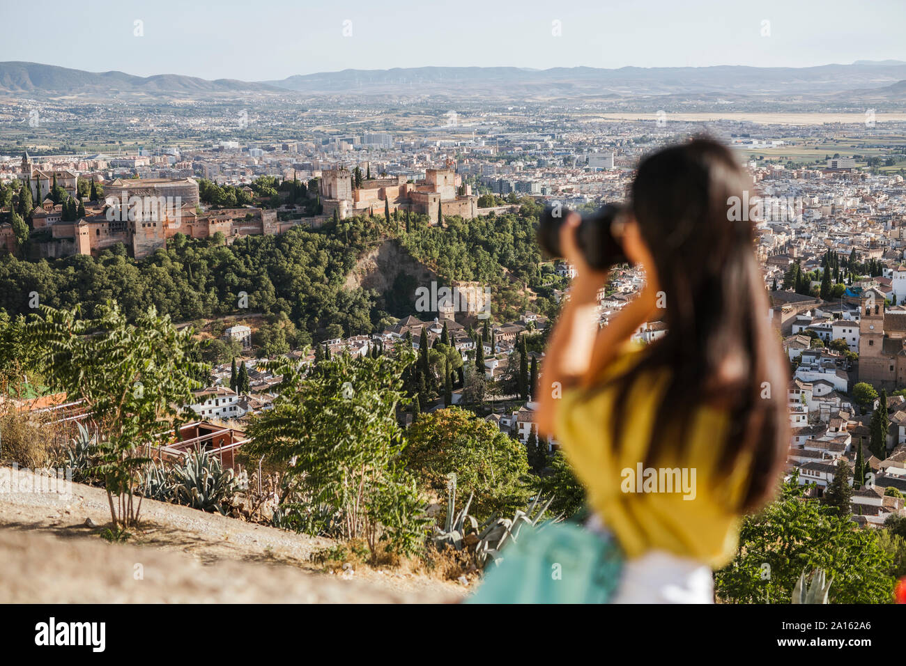 Giovane donna di scattare una foto a La Alhambra di Granada, Spagna Foto Stock