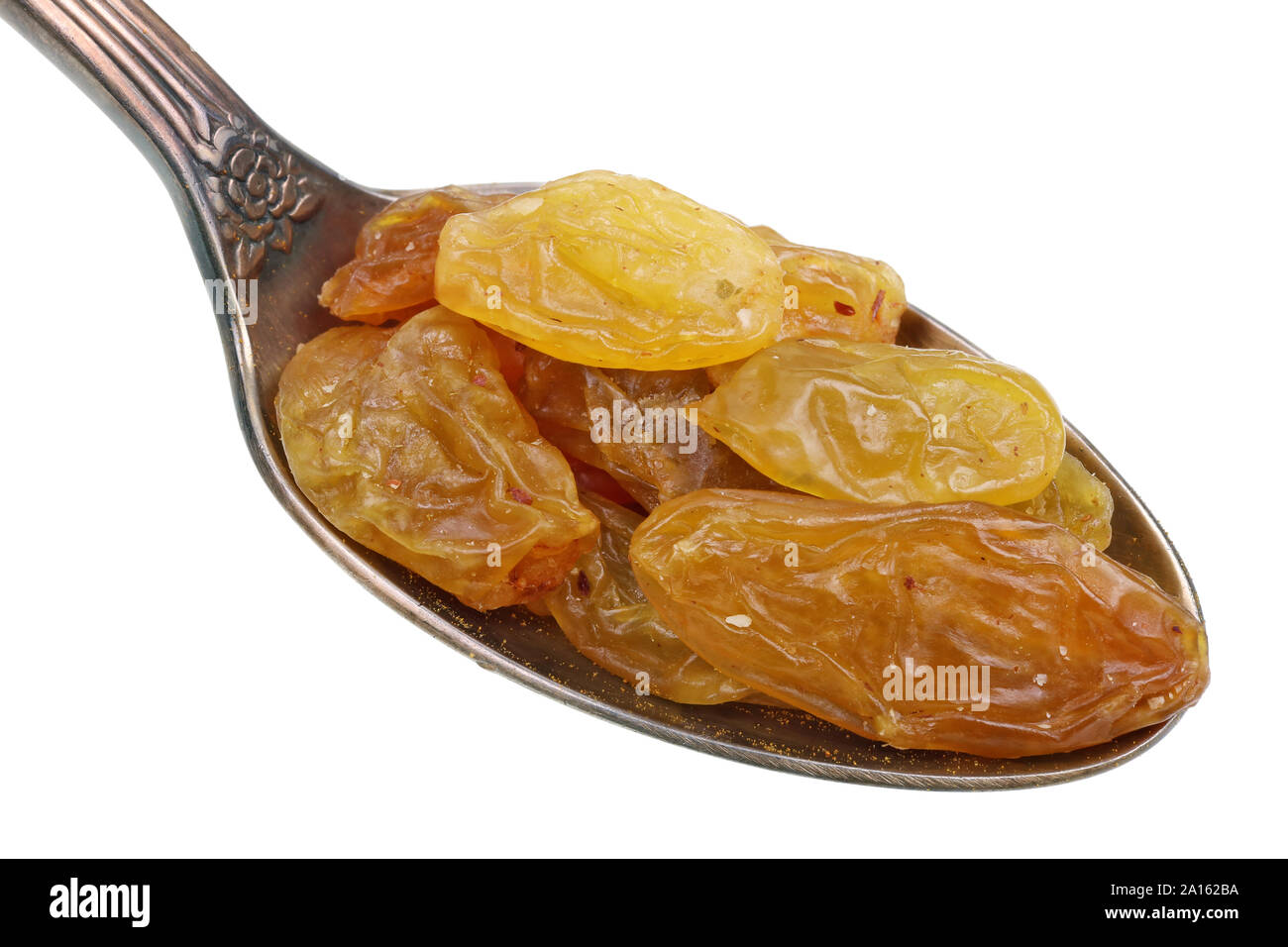 Nel vecchio il cucchiaio d'oro vi è un piccolo mucchio di cibo - ambra secco rasins frutti bacche. Isolato su bianco studio macro Foto Stock