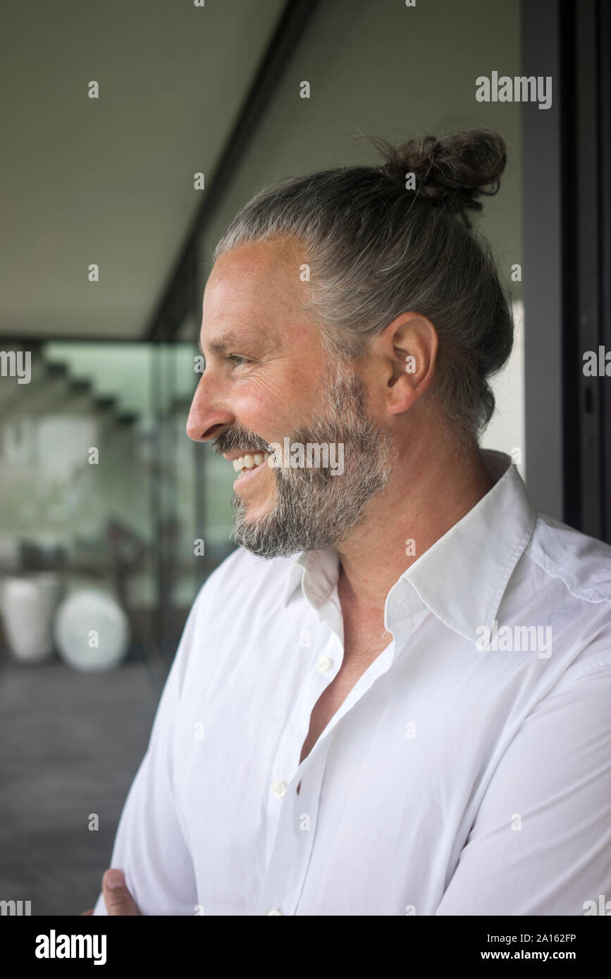 Ritratto di felice uomo maturo con i capelli bun Foto Stock