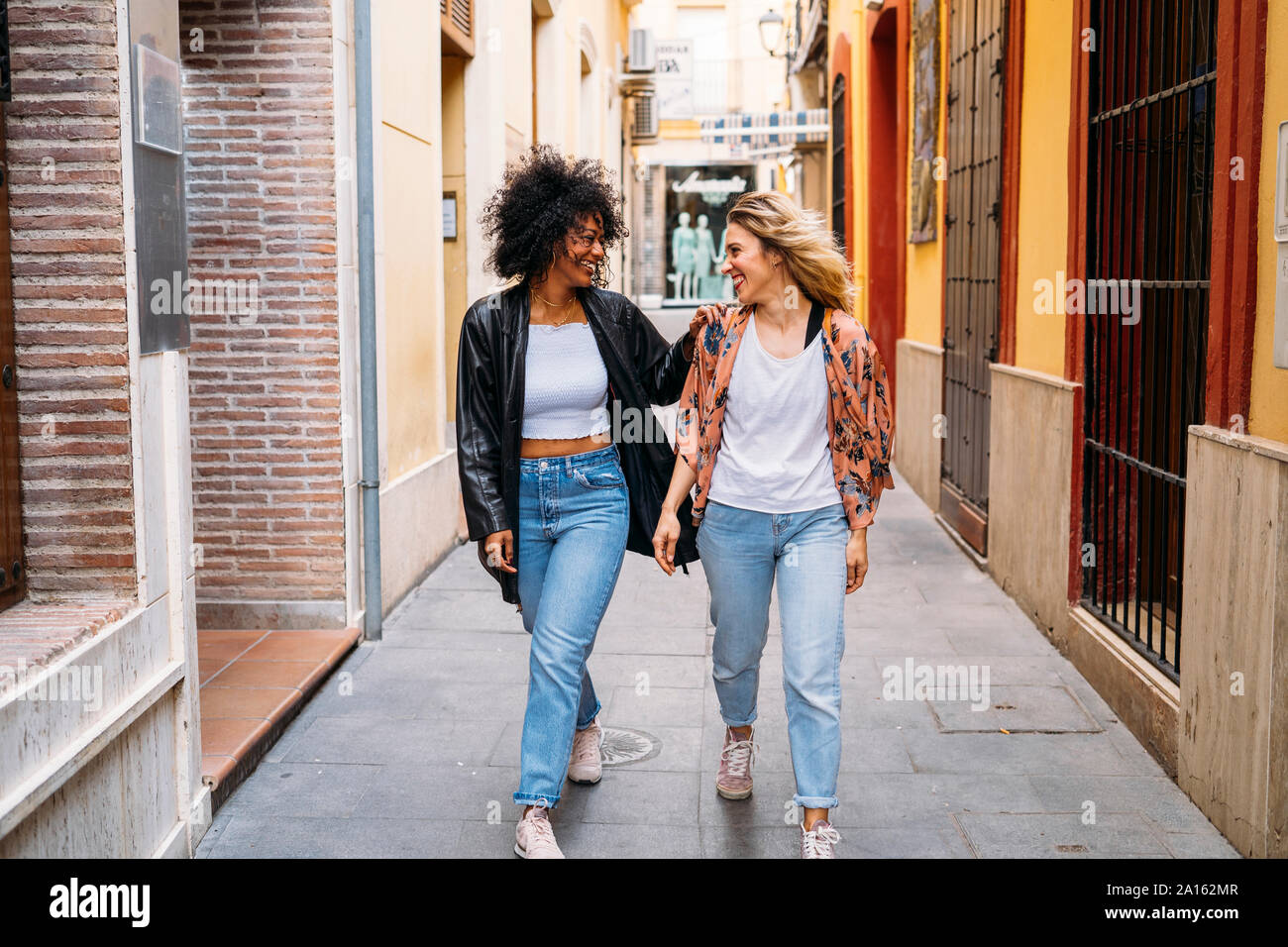 Multicultural felici donne a piedi nella città di Almeria, Spagna Foto Stock