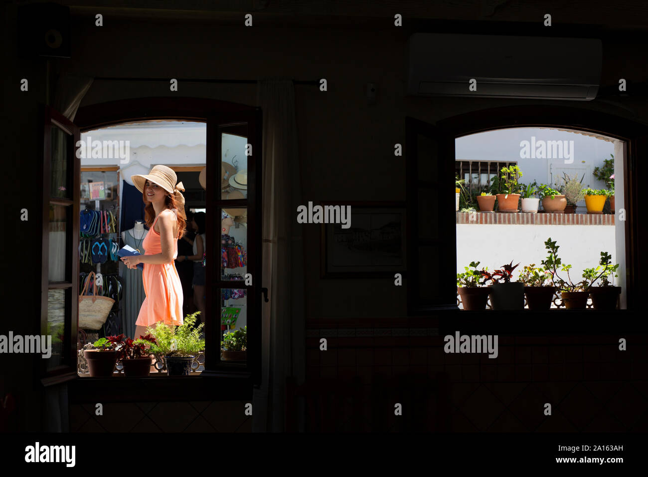 Moda giovane donna passeggiate turistiche in un vicolo, visto dall'interno, Frigiliana, Malaga, Spagna Foto Stock