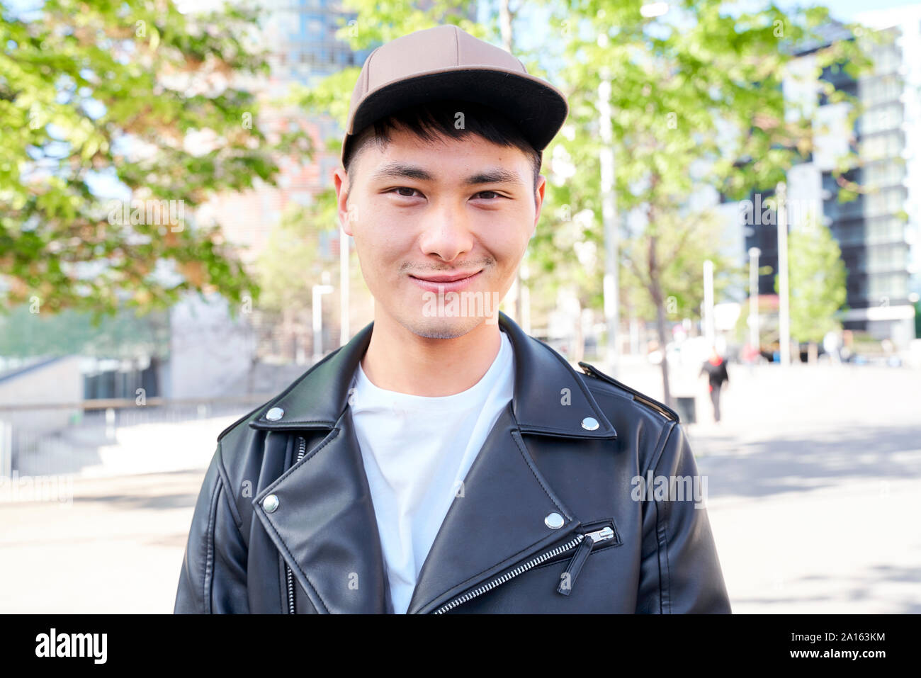 Ritratto di fiducioso giovane uomo indossando giacca di pelle e cappello, Barcellona, Spagna Foto Stock