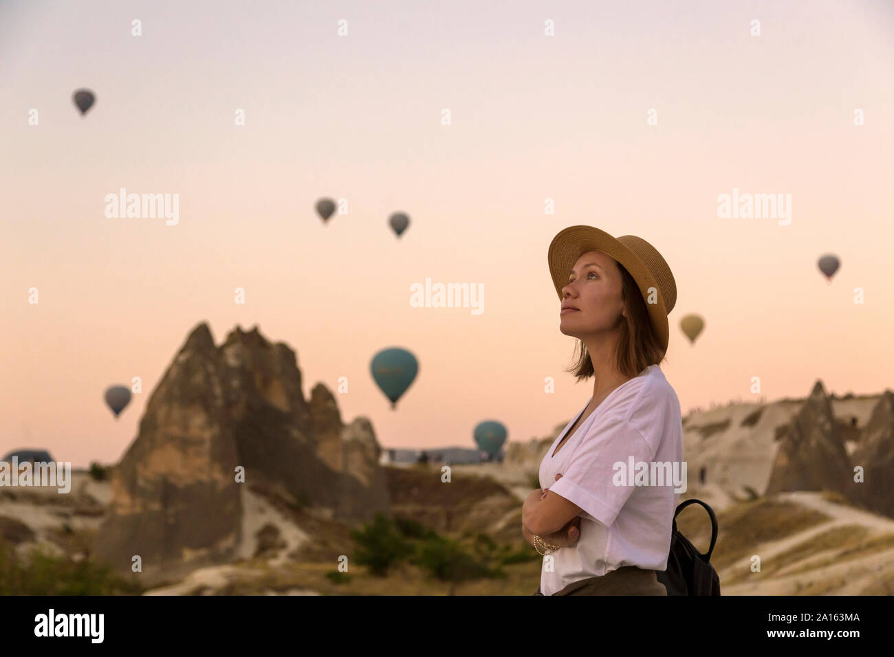 Giovane donna e aria calda ballons, Goreme, Cappadocia, Turchia Foto Stock