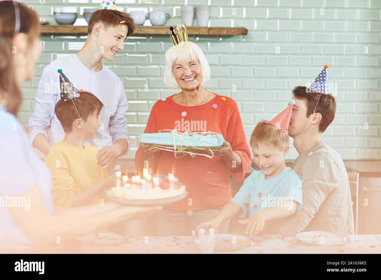 Madre e figli celebrando alla nonna bithday nella loro cucina Foto Stock