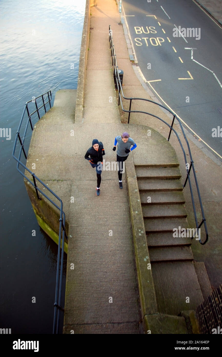 Due adolescenti jogging lungo un fiume Foto Stock