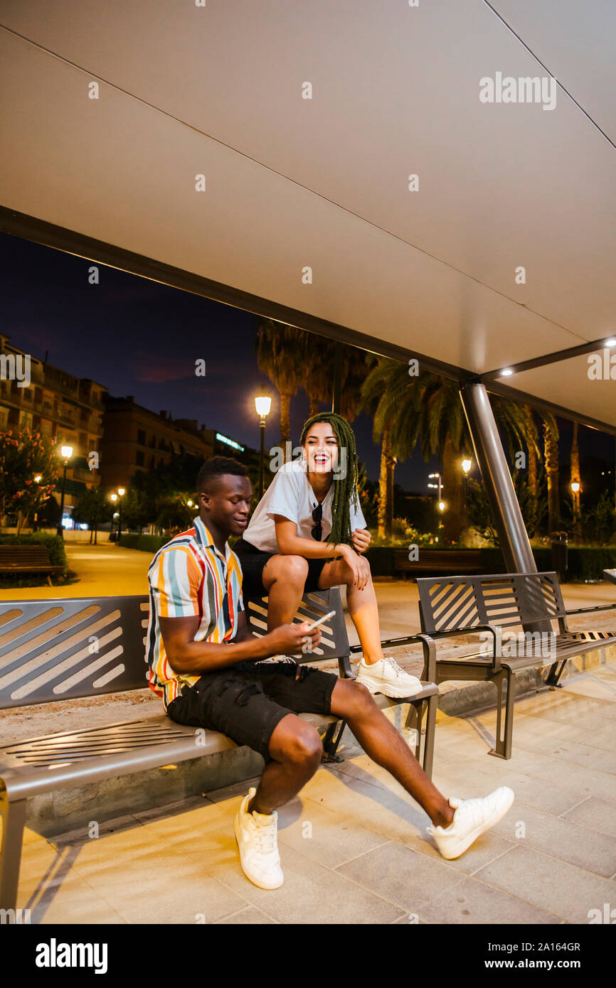 Cool coppia giovane su un banco di notte nella città Foto Stock
