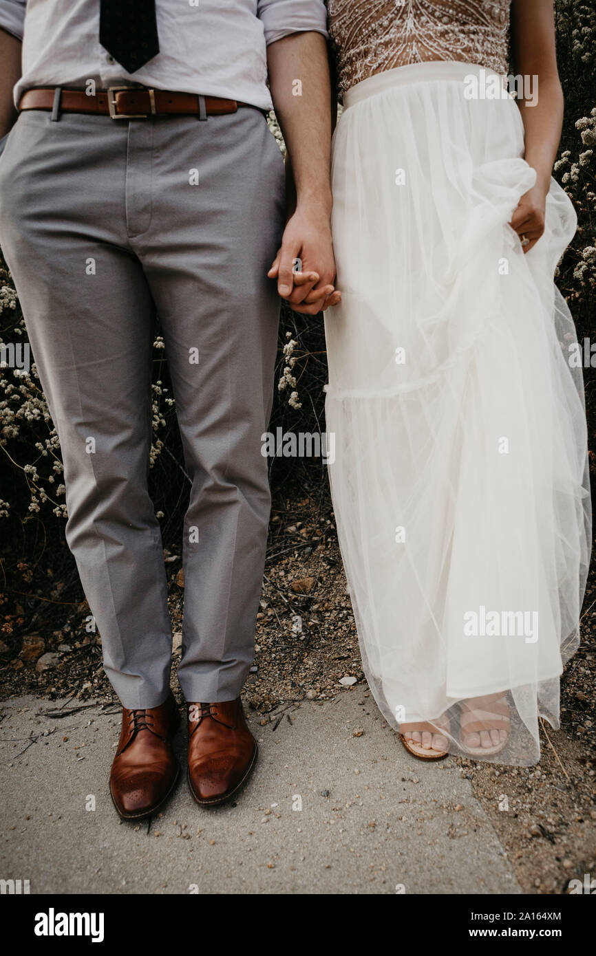 Sezione bassa della sposa e lo sposo tenendo le mani all'aperto Foto Stock
