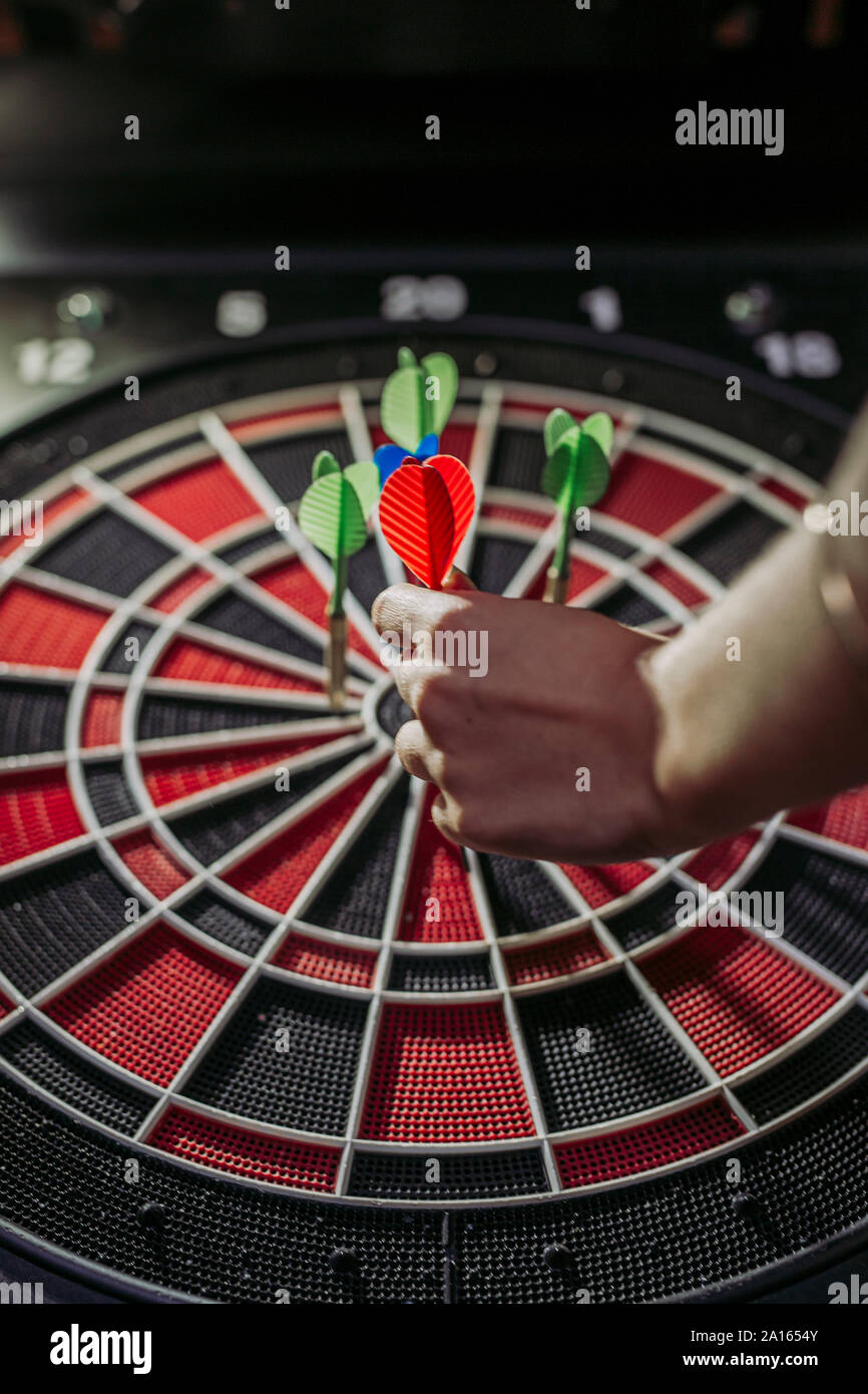 Close-up di donna di mano con freccette in electronic dartboard Foto Stock