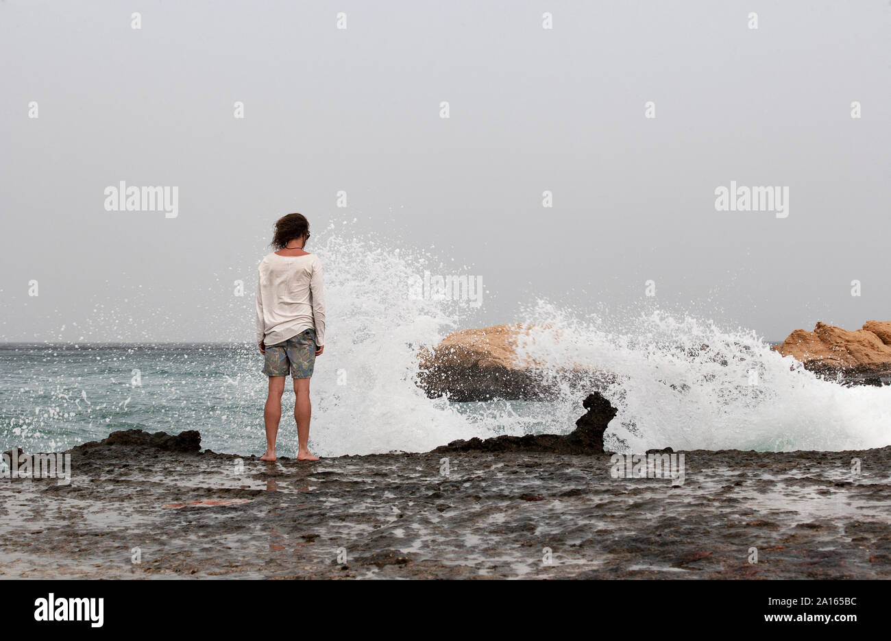 Vista posteriore di uomo in piedi sul lungomare, Golfo di Oman, vicino Sur,  Oman Foto stock - Alamy