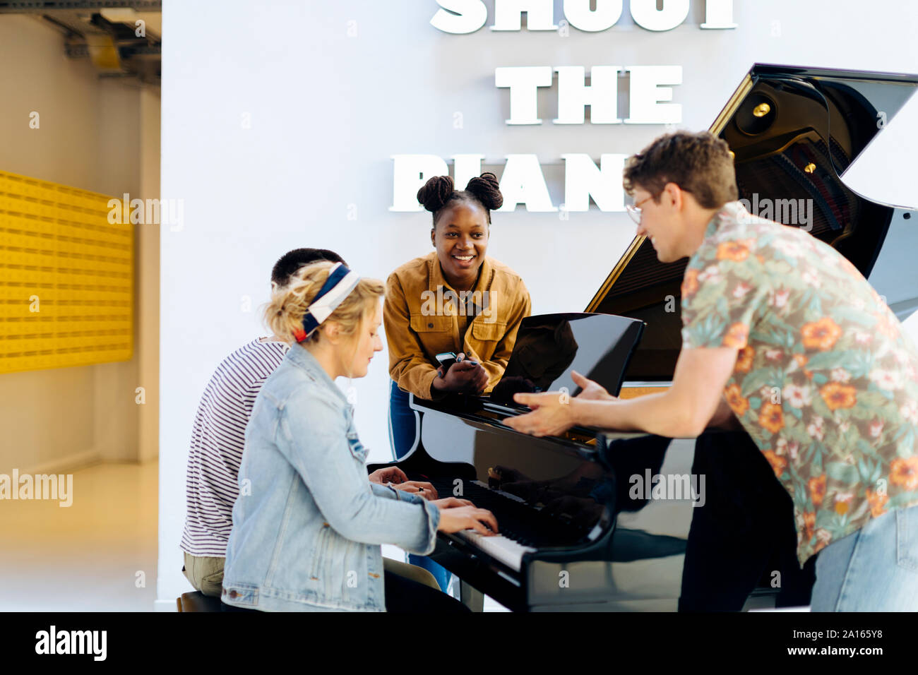 Gli studenti havig divertente, giocando un pianoforte insieme Foto Stock