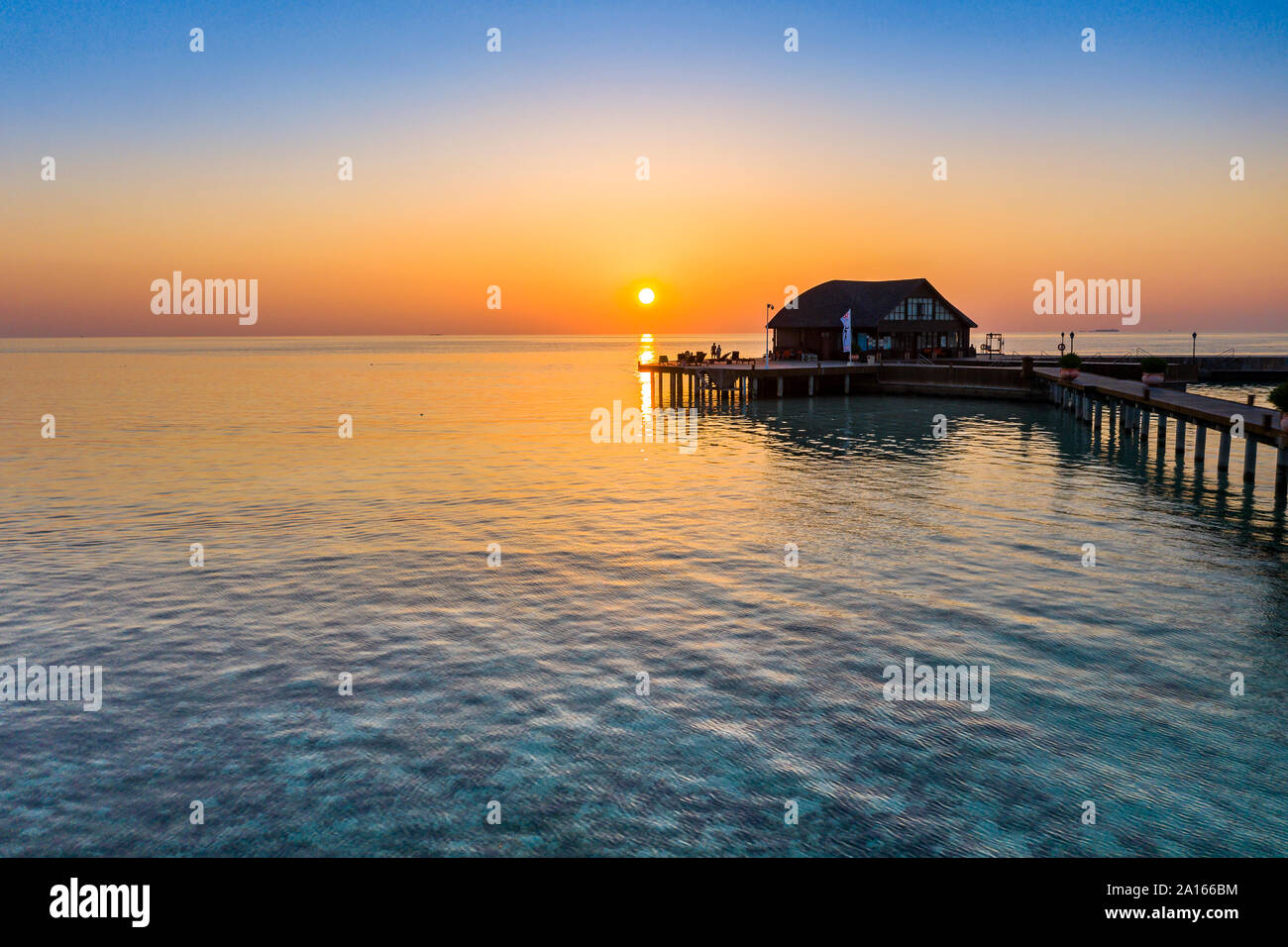 Maldive Olhuveli island, Pier e scuola di immersioni edificio sulla South Male Atoll laguna al tramonto Foto Stock