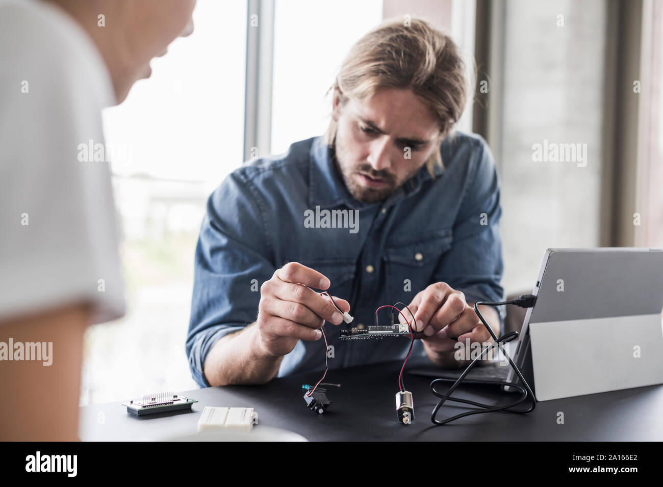 Giovane uomo e donna che lavorano su apparecchiature per computer in ufficio Foto Stock