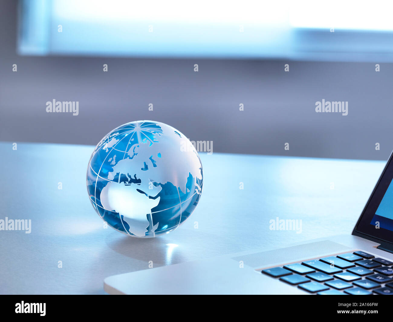I mercati globali, un globo di vetro con un laptop Foto Stock