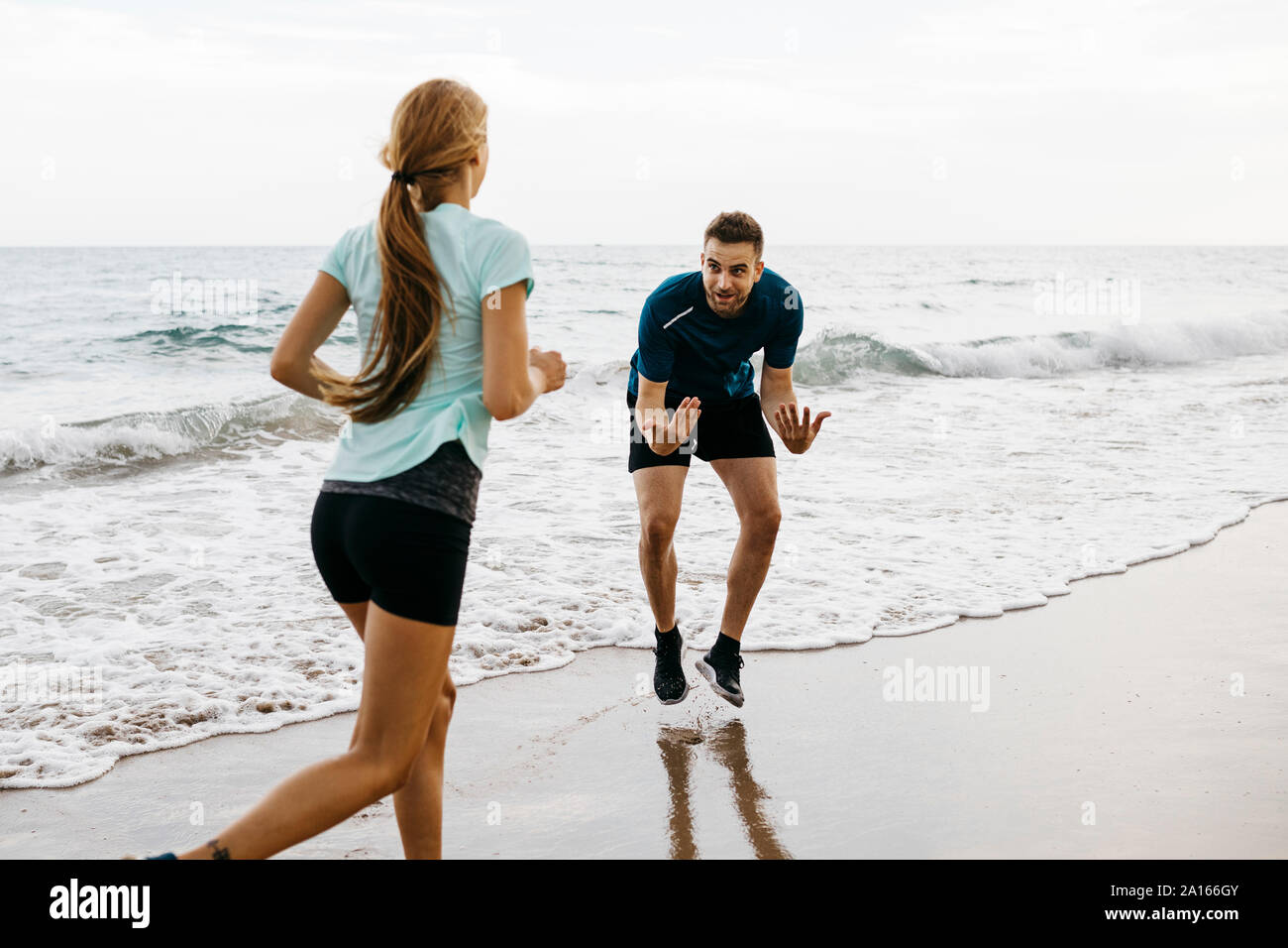 Pareggiatore femmina sulla spiaggia con il suo allenatore Foto Stock
