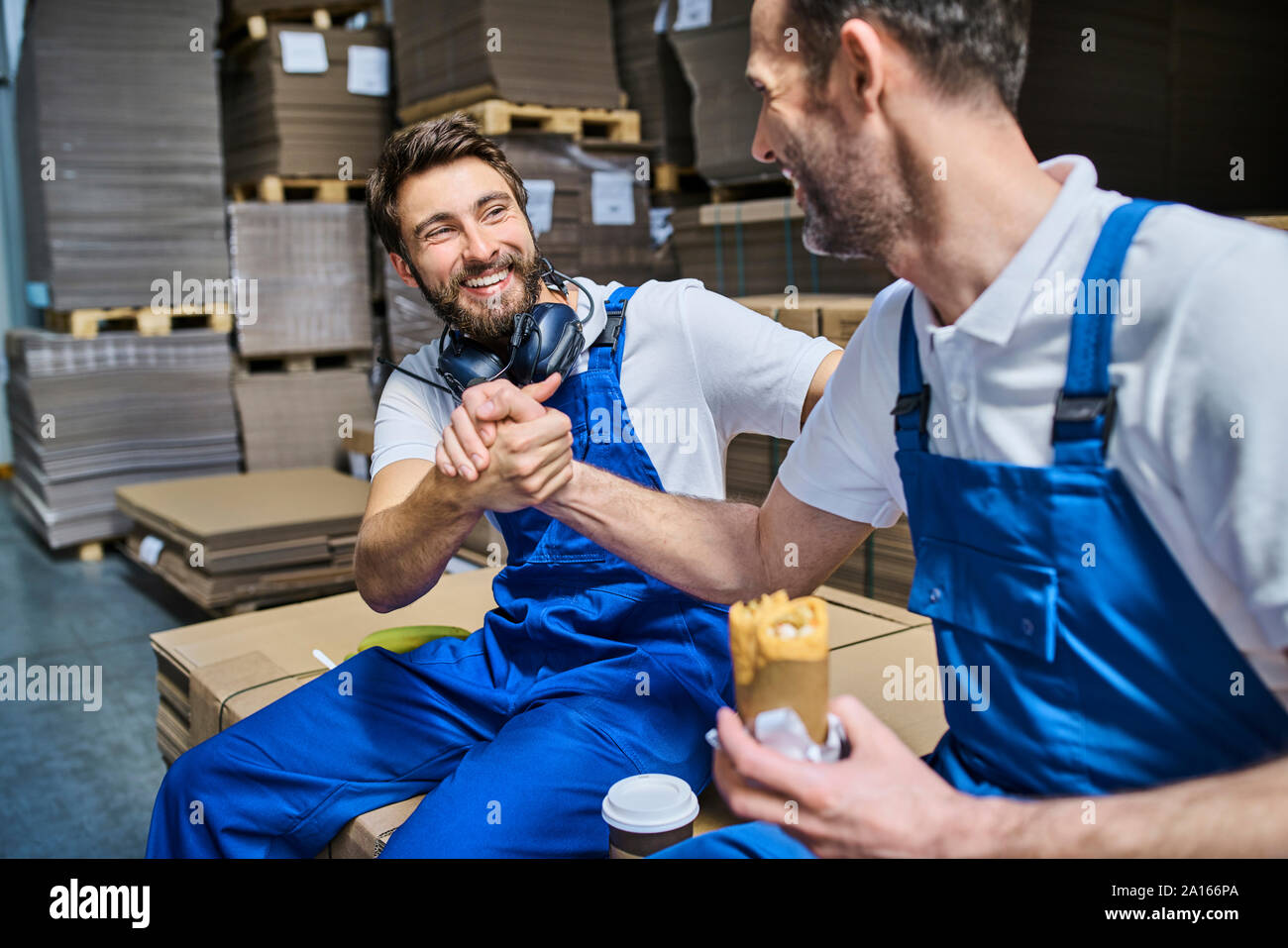 Due lieti i lavoratori aventi la pausa pranzo in fabbrica Foto Stock