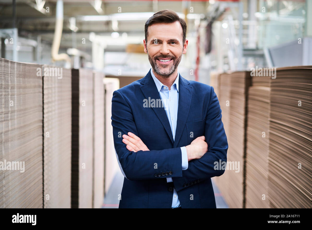 Ritratto di imprenditore sorridente nel magazzino di fabbrica Foto Stock