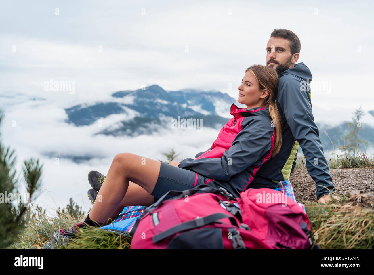 Affettuosa giovane coppia in una escursione in montagna avente una pausa, Herzogstand, Baviera, Germania Foto Stock