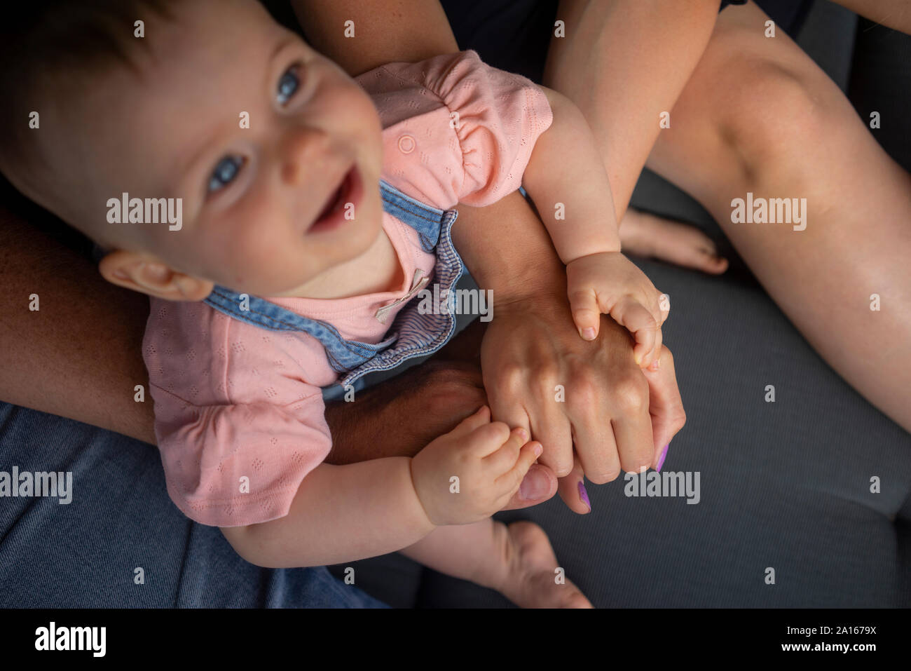 Le mani dei genitori e bambina Foto Stock