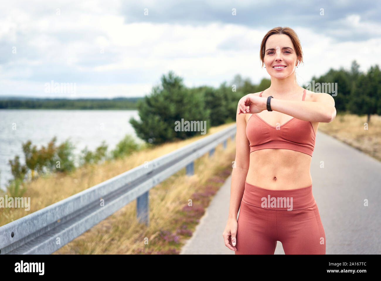 Ritratto di donna fit controllo smartwatch durante il jogging all'aperto la sessione Foto Stock