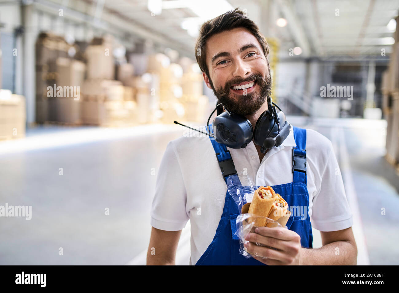 Felice lavoratore avente la pausa pranzo in fabbrica Foto Stock