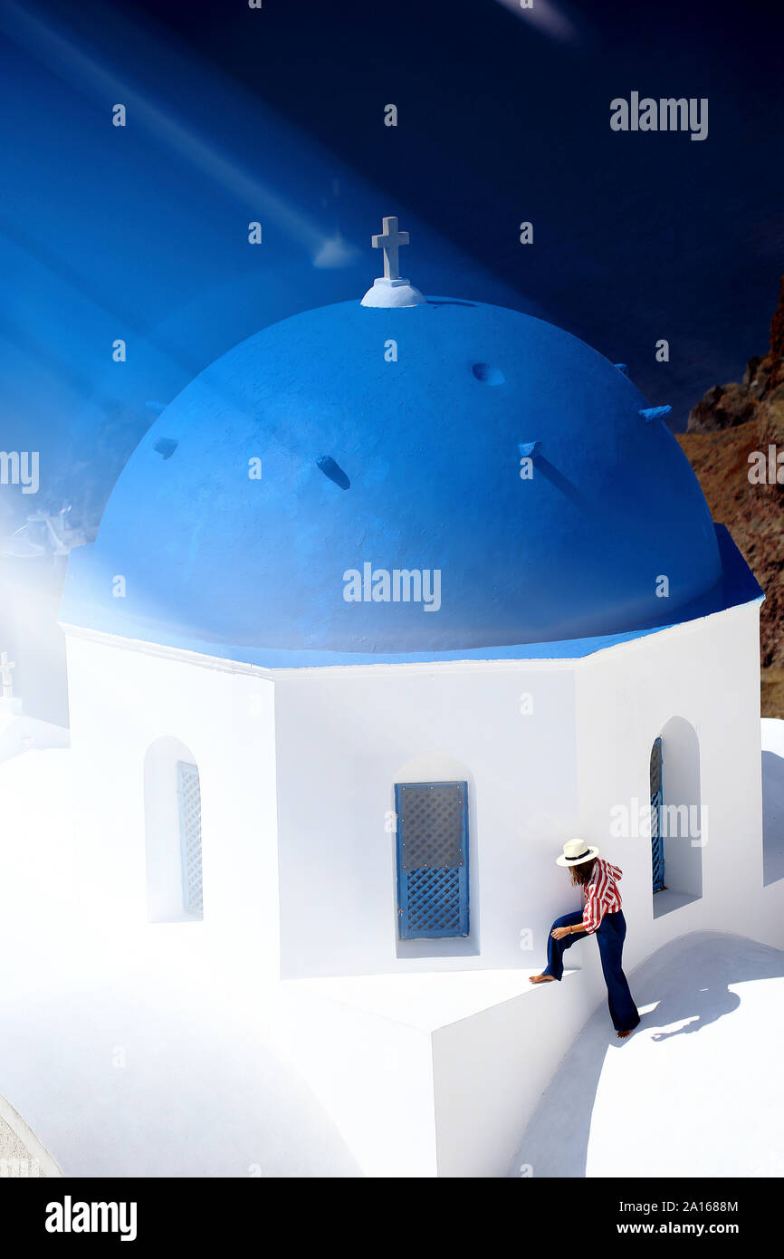 Donna sulla sommità di una cupola blu chiesa top, Santorini, Grecia Foto Stock