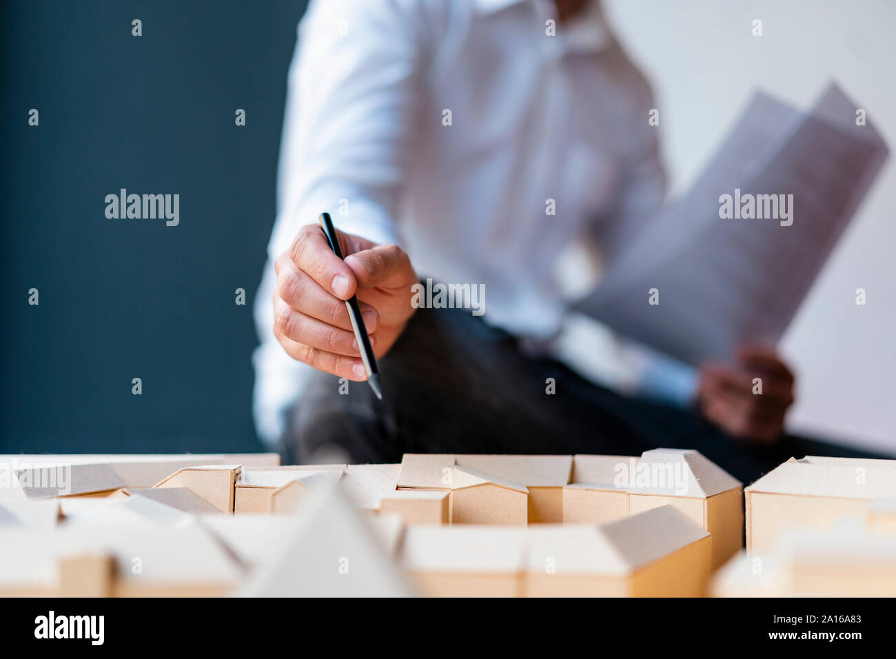 Close-up di uomo con la matita puntando al modello architettonico in office Foto Stock