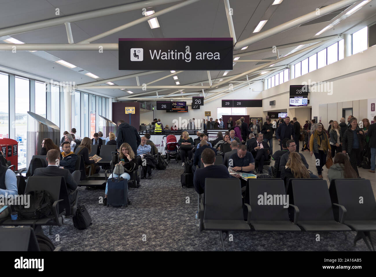 Dh sala Partenze aeroporto di Edimburgo EDINBURGH Persone in area di attesa passeggeri pronto a salire a bordo del aereo aeroporto occupato Foto Stock