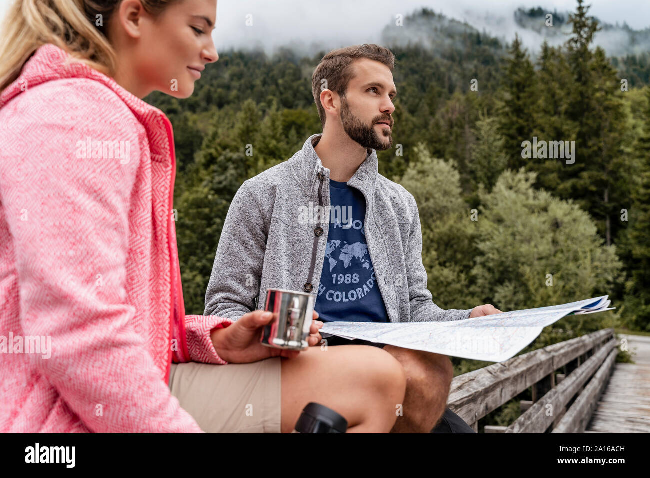 Una giovane coppia in un viaggio escursionistico con drink e mappa, Vorderriss, Baviera, Germania Foto Stock