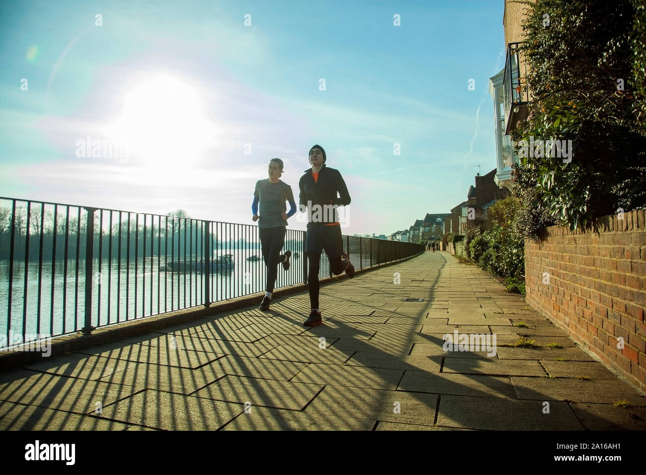 Due adolescenti fare jogging lungo il fiume Tamigi, London, Regno Unito Foto Stock