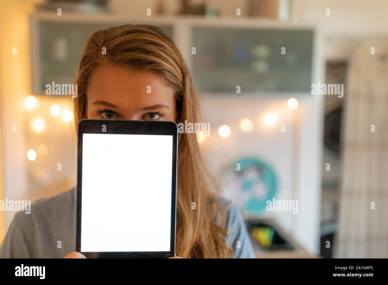 Ritratto di giovane donna di casa che mostra la schermata tablet Foto Stock