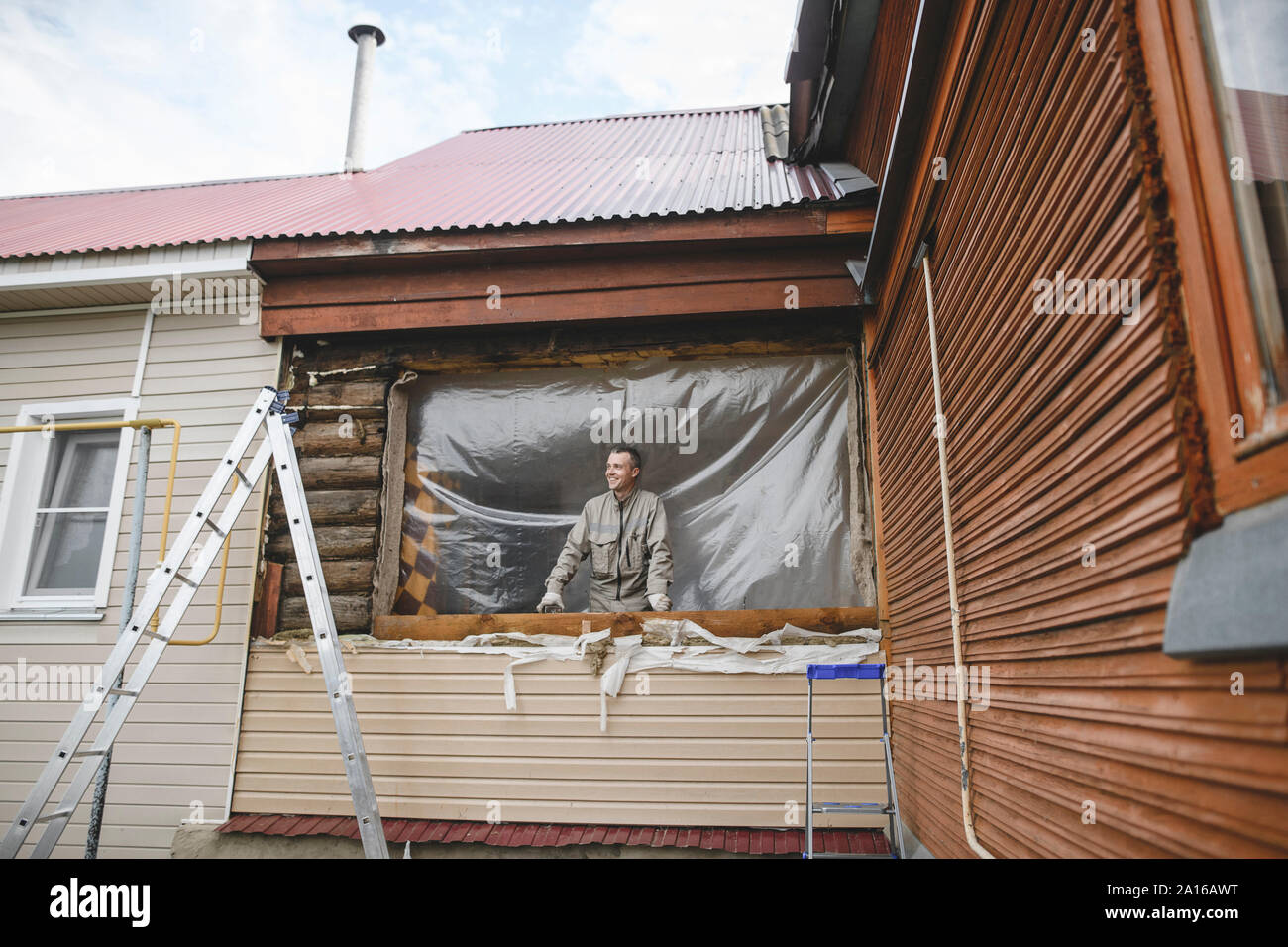 Uomo che ripara le finestre della sua casa Foto stock - Alamy