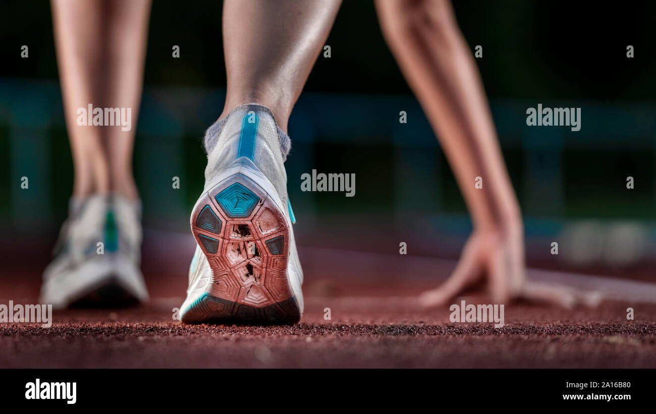 Gambe di atleta femminile in esecuzione sulla pista di tartan Foto Stock
