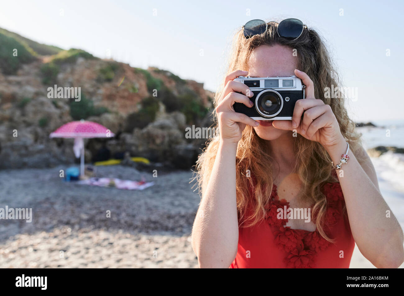 Giovane donna di scattare una foto sulla spiaggia Foto Stock