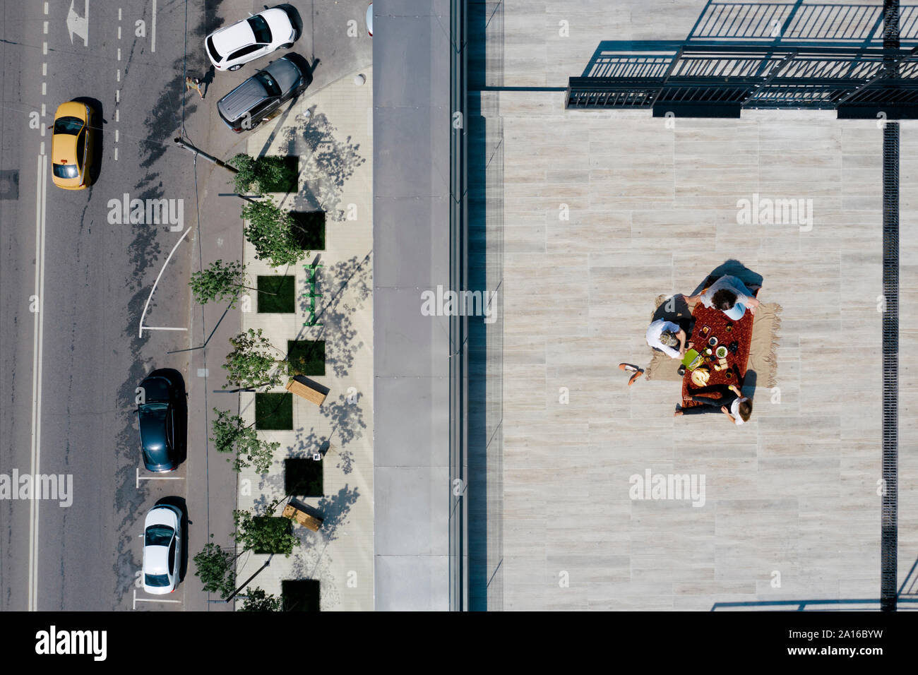 Vista aerea di tre persone aventi un pasto sul tetto Foto Stock