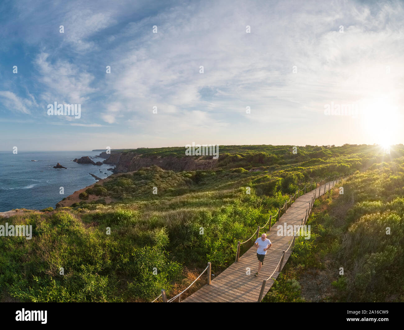 Portogallo Alentejo, senior uomo jogging sulla passerella in legno Foto Stock