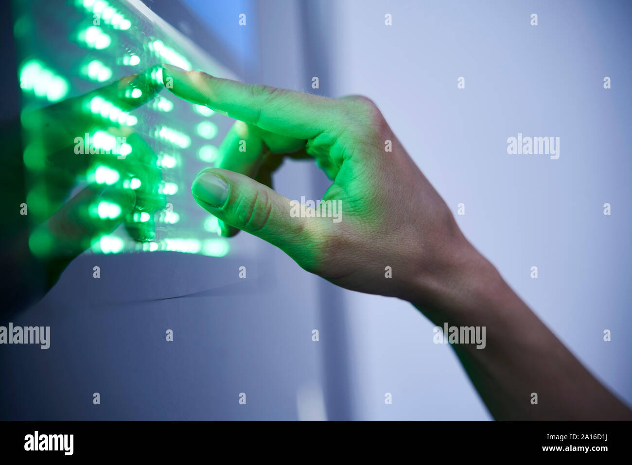 Dettaglio del dito tocchi il led verde display touchscreen Foto Stock