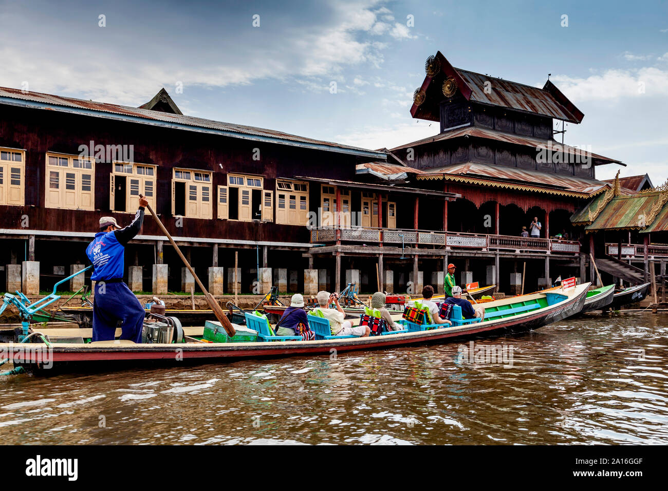 I turisti in un tour in barca passano dalla Nga Hpe Kyaung (Jumping Cat monastero), il Lago Inle, Stato Shan, Myanmar. Foto Stock