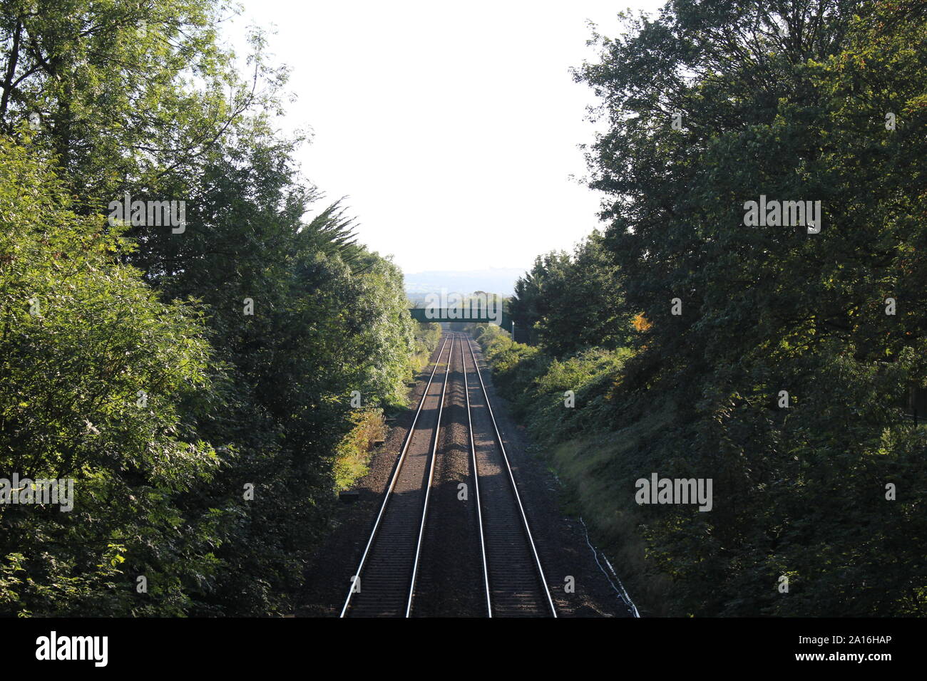 Immagine di una traccia ferroviaria presa da un ponte sopra la linea, che conduce le linee in distanza Foto Stock