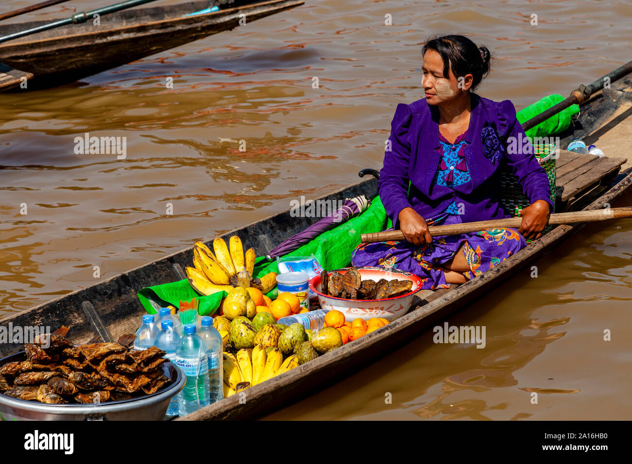 Una donna birmano la vendita di frutta fresca e spuntini da una barca sul Lago Inle, Stato Shan, Myanmar Foto Stock