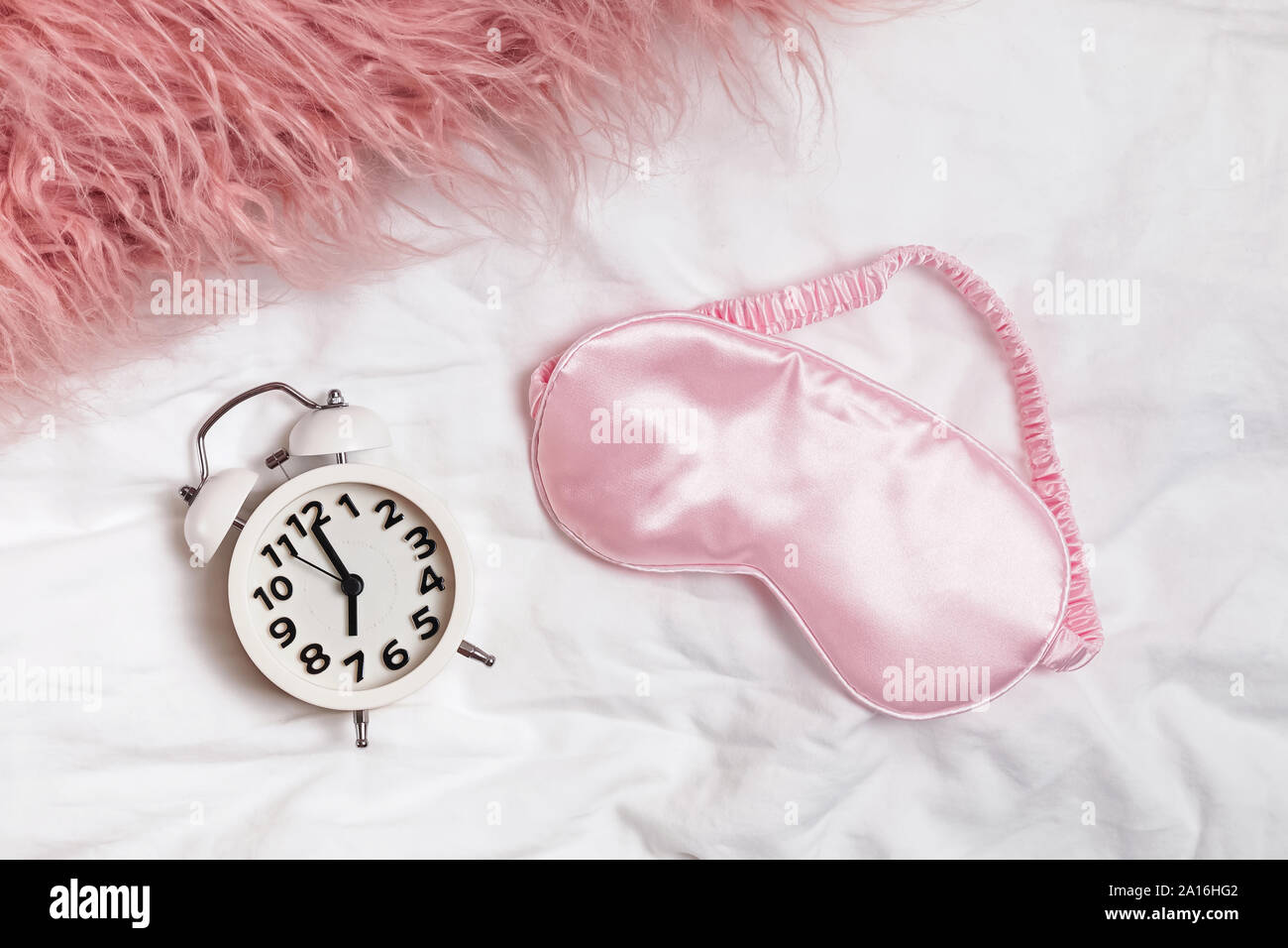 Sveglia e rosa maschera di slittamento sul letto, Foto Stock