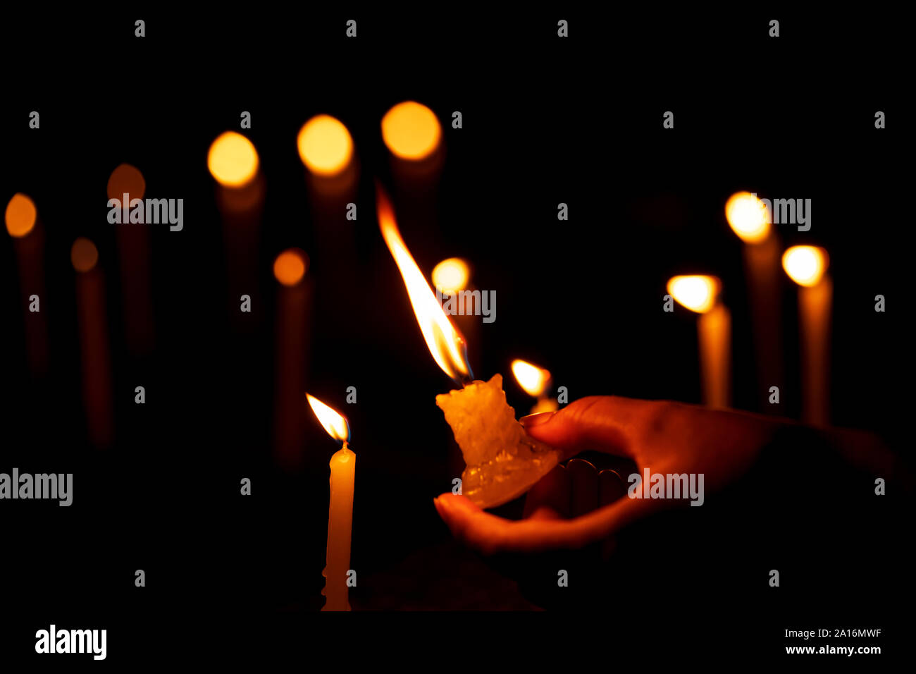 Femmina illuminante a mano o l'illuminazione delle candele accese di notte, tempio, chiesa. Magazzino immagine di sfondo per la decorazione di Diwali, vacanze, banner, festosa r Foto Stock