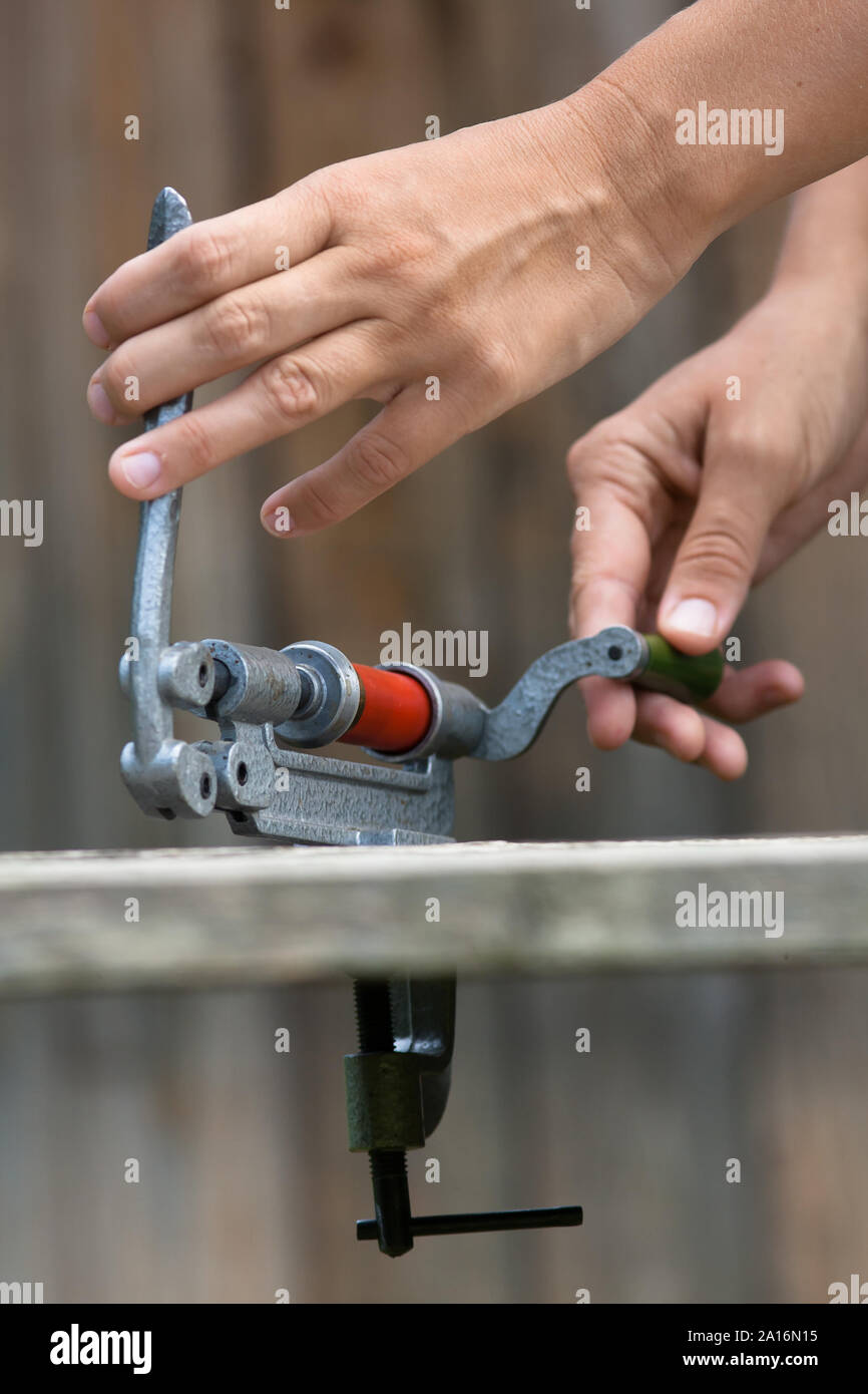 Le mani della cartuccia di ricarica dal guscio shotgun reloader, primo piano Foto Stock