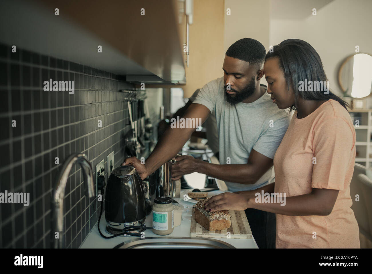 Giovane americano africano giovane prepara la colazione in cucina Foto Stock