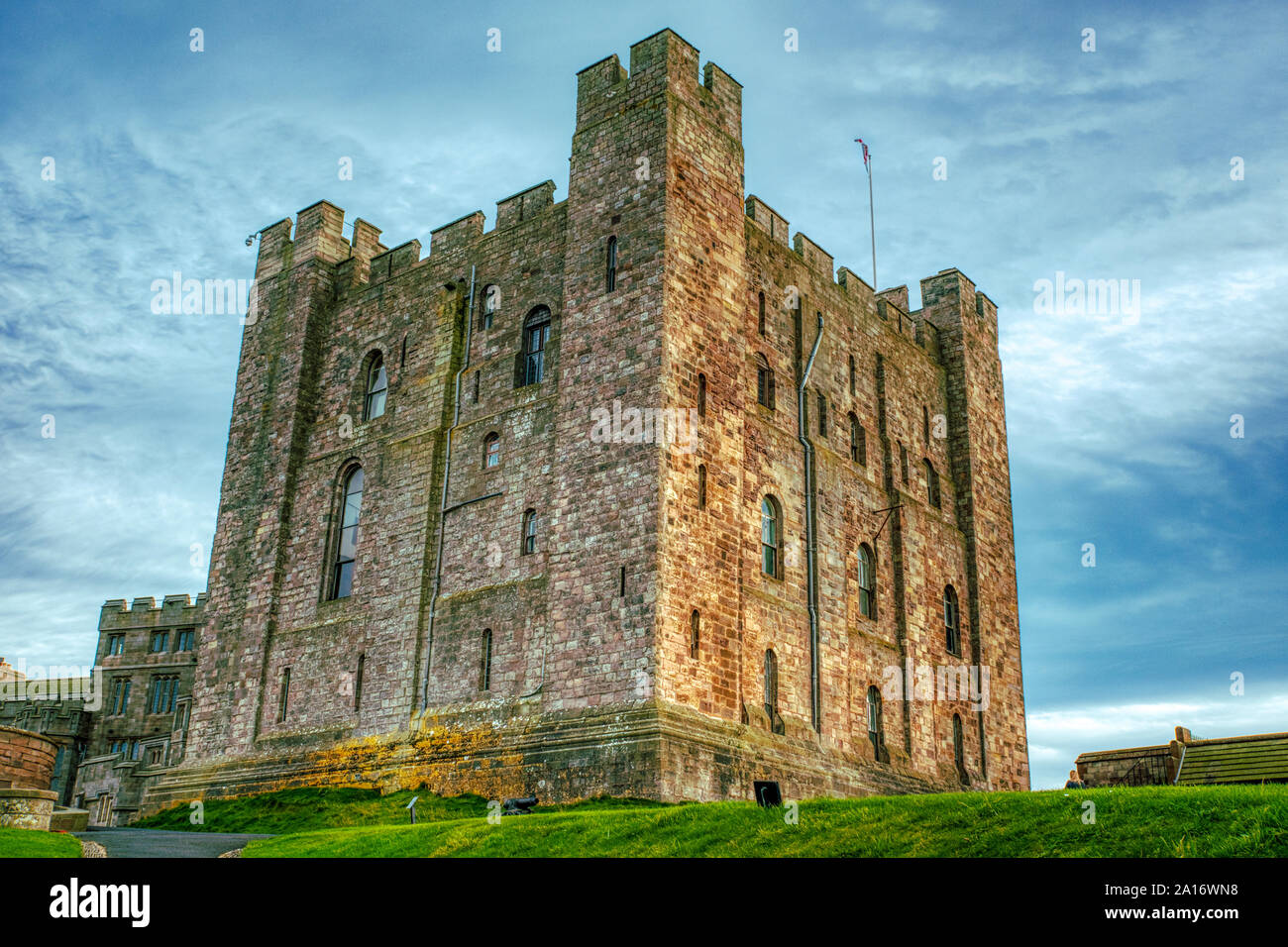 Il castello di Bamburgh tenere, impostare contro un cielo blu, Bamburgh, Northumberland, Regno Unito Foto Stock