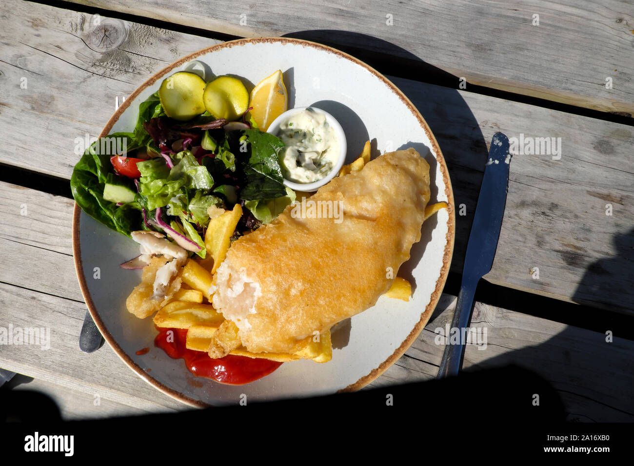 Squisiti piatti a base di pesce e patatine & insalata pasto servito al di fuori su di un tavolo da picnic al ristorante Runwayskiln in Marloes Pembrokeshire Wales UK KATHY DEWITT Foto Stock