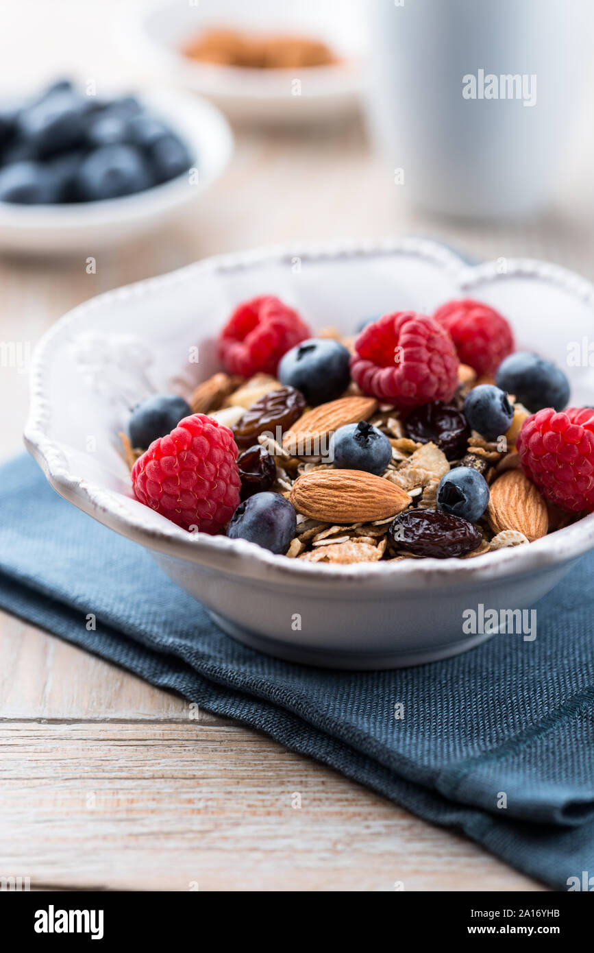 Ciotola di muesli con frutta fresca, mandorle e uvetta Foto Stock