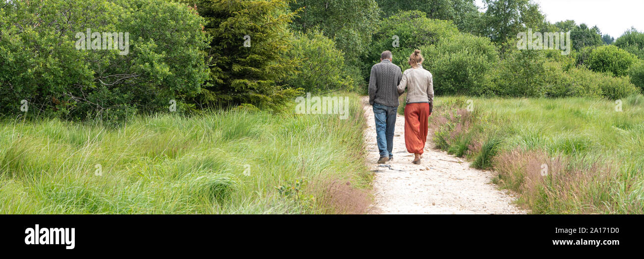 Coppia di anziani a piedi lungo un percorso verso un futuro sconosciuto Foto Stock