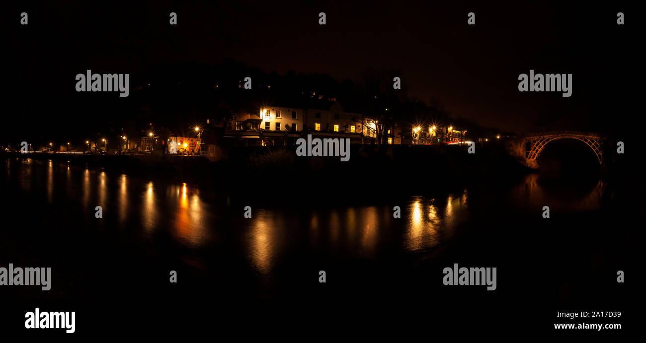 Panaroma di banchina a città di Ironbridge, Shropshire sul fiume Severn durante la notte con le luci di strada che riflette nell'acqua. Foto Stock