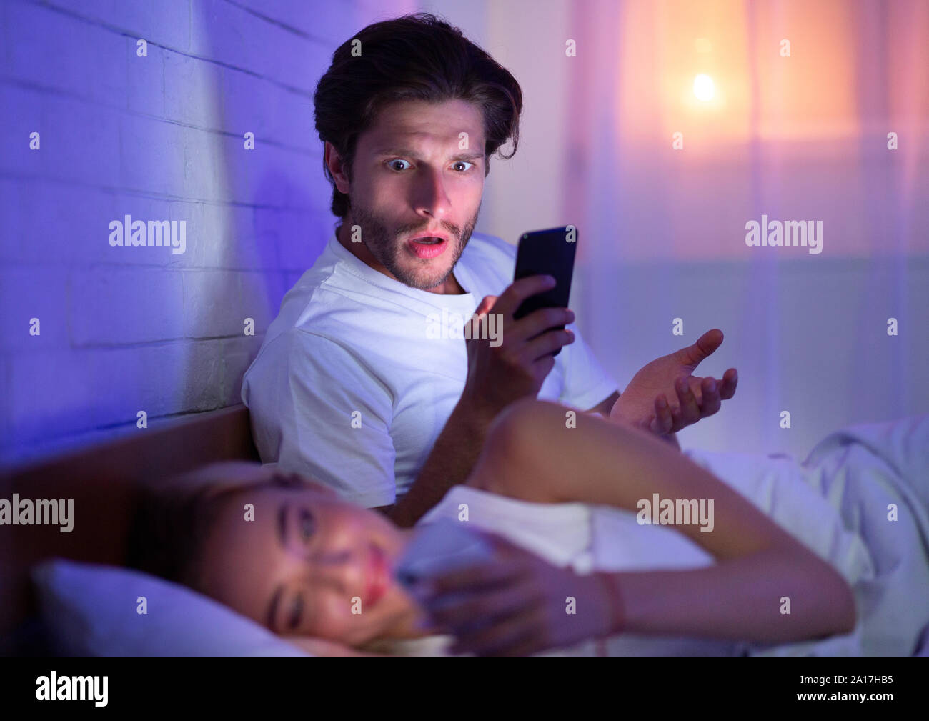 La cattura del marito moglie Chat sul telefono nel letto di notte Foto  stock - Alamy