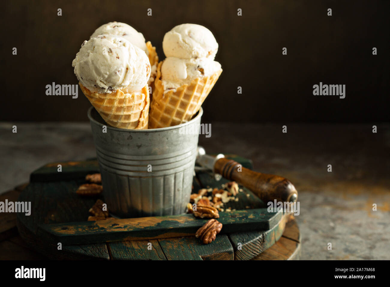 In casa alle noci pecan e caramello coni gelato su sfondo scuro Foto Stock